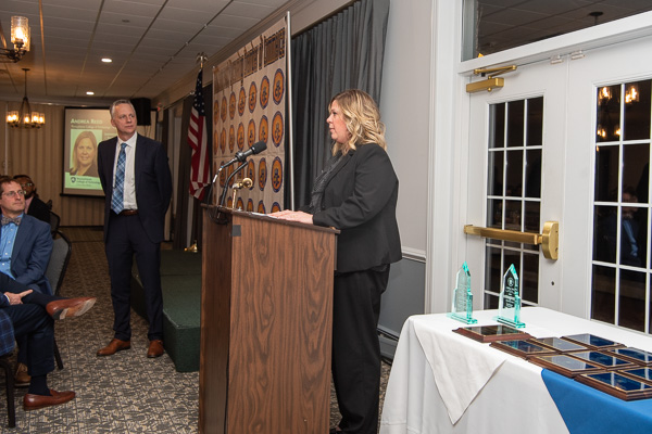 Andrea Reed accepts her award; seated at left is Jason Fink, president/CEO of the Williamsport/Lycoming Chamber of Commerce.