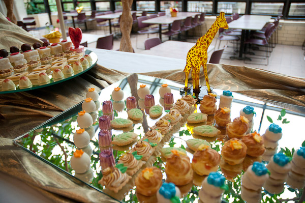 A giraffe from "The Lion King" strolls through festive flora and fauna.