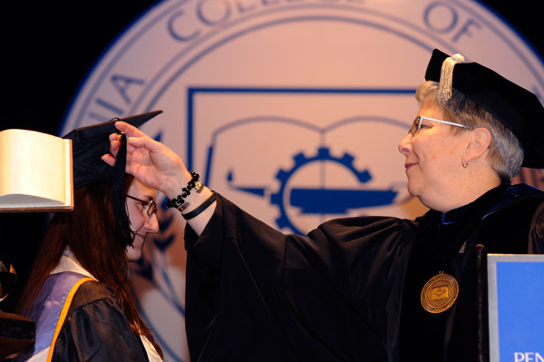 In a scene repeated with student speakers throughout the weekend, President Gilmour turns the tassel of Alison R. Beitz, class representative at Friday's ceremony.