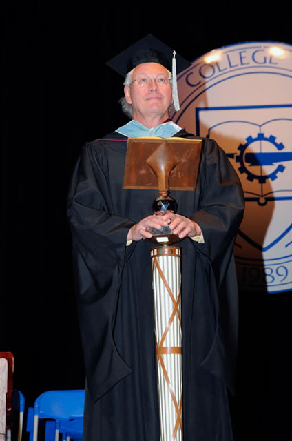 Carrying the mace for his final commencement is Jim E. Temple, who retired this year as assistant professor/department head of electrical technology/occupations and Penn College Education Association president.
