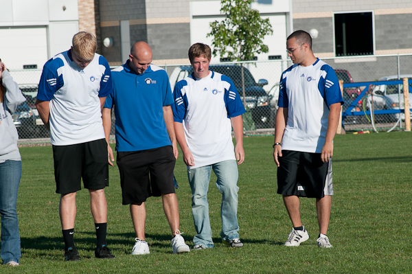 New tennis coach Robert Kemrer (second from left), an alumnus of the Wildcat tennis team, joins his squad at midfield.