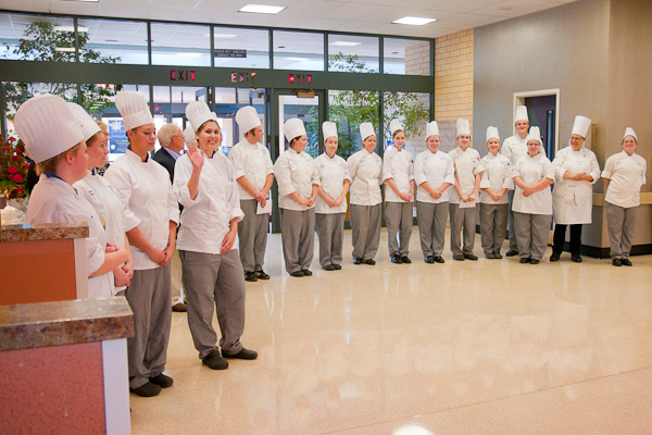Nina M. Liguori, of Forty Fort, a graduating sophomore in baking and pastry arts, waves to the crowd amid the cast of culinary creators in the spotlight.