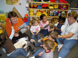 Kathryn P. Jerald, group leader (left), and Sandra L. Hollingsworth, assistant group leader, talk about turkeys with Children%E2%80%99s Learning Center toddlers. (Photo by Sonya K. Miller, assistant group leader, Children's Learning Center)