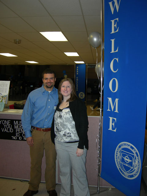 Alumni Cory D. Keys and Dee E. Bilger, who later got engaged in a college parking lot, greet visitors to the Field House.
