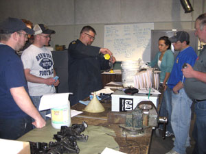 Claude T. Witts,(center) instructor of diesel equipment technology at Pennsylvania College of Technology, mixes diesel fuel and vegetable oil, surrounded by (from left) students Jeremy R. Bell, Benjamin E. Smith, Katie L. Hoffman and Lucas E. Larson, and Steven R. Parker, instructor of environmental technology.
