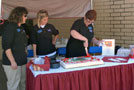 Linda L. Szuhaj, Madigan Library operations assistant, cuts the cake, joined by Jean M. Bremigen, operations manager (left), and Blair E. Smith, support services assistant