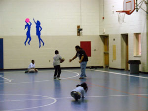 Saeed Al-Ghamdi plays basketball with children at The Campbell Street Youth, Family and Community Association - better known as The Center.