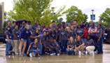 Teens quickly gather outside the Madigan Library for a group shot, sandwiched between a cloudburst and lunch