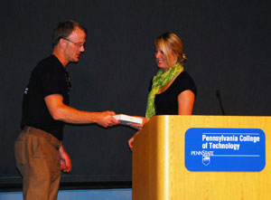 CACCE adviser Jeremiah C. Gee accepts the organization's award from Jessica R. Larson, SGA's vice president of public relations.