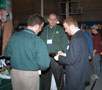 Alumni Jason Tolley, left, and Tom Paisley talk with Lane Ackerman, a construction management major, at The H&K Group booth