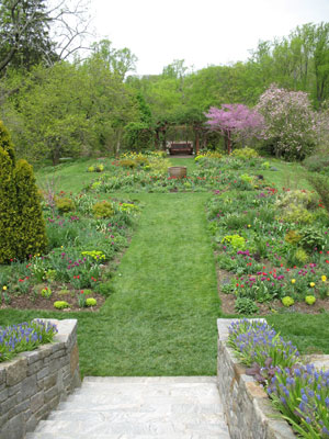 An inviting walkway slopes toward garden's greenery.