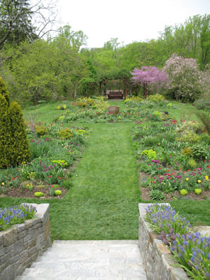 An inviting walkway slopes toward garden's greenery.