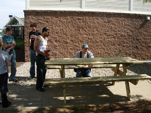 Chip Rizzo, Benaiah Tucci and Israel Laguer putting finishing touches on a table.