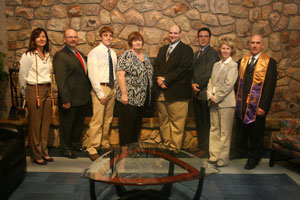 The newest members of the Lambda Nu Chapter of Delta Mu Delta are joined by Gayle Kielwein, vice president/secretary (left), and Joseph R. Raup, chapter president (right).
