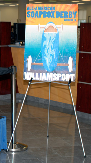 A poster announcing the return of the 'All-American Soap Box Derby' to Williamsport, displayed in Penn College's Madigan Library, was designed by Donald Noviello's son, Cristopher, a graphic designer who attended Penn College for advertising art and later graduated from the Art Institute of Pittsburgh.