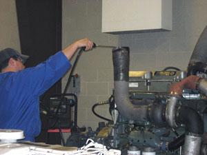 Environmental technology management major Lucas E. Larson samples engine emissions.