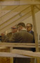 Glimpsed through the skeleton of student work, Bridgens leads Ritchey and James Brown, vice president of Erie's material damage department (right) through the construction carpentry lab