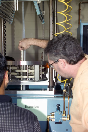 Donovan Henrie, of Rieter Automotive Systems in Bloomsburg, takes measurements during a hands-on workshop on blown-film extrusion.