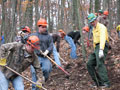 Students build a fire line in the woods