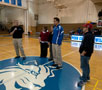 SGA President Kyle M. Pfueller, with microphone, joins food-bank representatives, among others, at half-court
