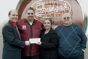 Family patriarch Franco Daniele, right, joins daughter Maria and son Fred in presenting a scholarship check to Robert C. Dietrich, left, executive director of the Penn College Foundation, outside Franco%E2%80%99s Lounge, 12 W. Fourth St.