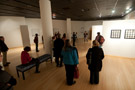 Gallery patrons form a tableau of their own, intent on the artist's words