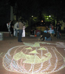 Children play Halloween games with RA Anthony R. Grubbs near artwork created by Village resident Michael Tatangelo.  