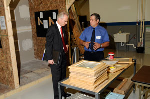 Weatherization Training Center instructor Gerald A. Welshans, right, demonstrates the glazing operations within the Weatherization Training Center for Fred Dedrick, deputy secretary for workforce development for the state Department of Labor %26 Industry.