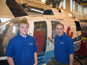 Scholarship recipients Christopher M. Gayman (left) and Justin A. Eshleman, seniors in Pennsylvania College of Technology%E2%80%99s aviation maintenance technology major, stand before a helicopter in the Lumley Aviation Center hangar at the Williamsport Regional Airport in Montoursville. (Photo by Thomas D. Inman, association professor of aviation)