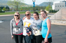 Ashkei Bower, a 2009 dental hygiene alumna; April Manley, a 1990 dental hygiene graduate, Amber L. March, a dental hygiene student, and Aimee Dreese pose with a young fan prior to the race start