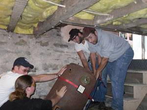 Brittany A. Hoey joins classmates in manuevering an old boiler up the stairs.