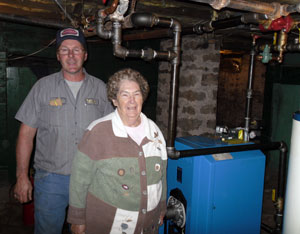 Contractor Robert W. Dittmar and homeowner Helen Rohm, alongside the woman's replacement boiler.