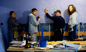 Joe S. Miller, Adam C. Swan, Gregory B. Neal and Rebecca R. Miller cover a kitchen wall in Yonkers, N.Y.