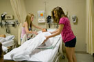 Campers make an occupied bed in the nursing lab