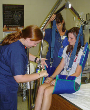 Pennsylvania College of Technology nursing students Jessica K. Lilley, left, of Lewisburg, and Sue A. Gigunito, of Montoursville, demonstrate how to use a lift to transfer a patient from a wheelchair to a bed during Health Careers Camp at the college. (Photo by Nate Smyth, assistant dean of health sciences)
