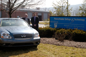 Pennsylvania College of Technology alumnus Anthony J. Piccari, right, delivers a 2006 Infiniti Q45 to Ronald A. Garner, automotive professor and one of his faculty mentors, outside the college%E2%80%99s Advanced Automotive Technology Center.