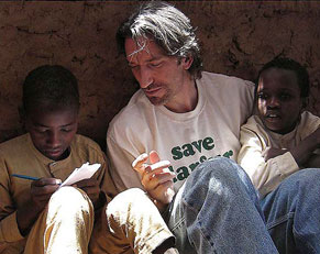 John Prendergast sits with two children in a rebel-held area of Darfur.