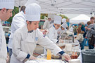 A long lineup of white hats cooks up a variety of delicious treats for Growers Market visitors