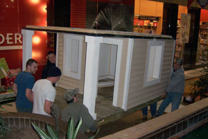Manuevering the miniature house into place at the Lycoming Mall, are counterclockwise from upper left, Construction Management Association members Thomasz Jezowski (dark blue sweatshirt), Justin J. Kovaleski, James P. Craft, Nicholas L. Fragello and Ryan P. Becker (grey sweatshirt).