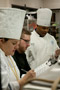 Darnell R. Bungy, right, of team Tails, explains his entrée  a roasted rabbit sandwich, vegetable napoleon and risotto cake with bacon, mushrooms and onions, to judges Mary G. Trometter and Christopher R. Grove
