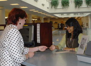 Circulation supervisor Nicole S. Staron issues the Madigan Library's first high school membership card to Tazrin Hossain.