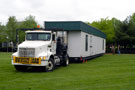The first of nine modular trailers is backed into place between the PDC and Victorian House