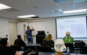 Jeffrey M. Januchowski, instructor of automotive technology at Penn College, uses both a whiteboard and the overhead projection system in a classroom within the Parkes Automotive Technology Center.
