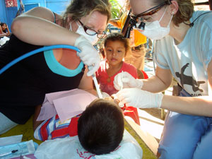 Pennsylvania College of Technology dental hygiene students Tango S. Marbaker, of Canton, left, and Karen J. Miller, of Linden, treat one of 105 elementary school students at La Escuelita in Managua, Nicaragua.