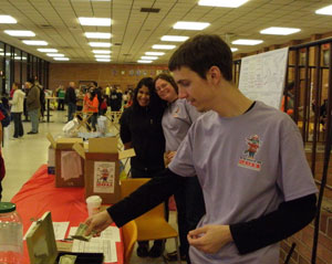 Among students staffing the Odyssey of the Mind merchandise table are Jordan M. Miller, foreground, and Jaritza A. Batista-Marcano, at left background.