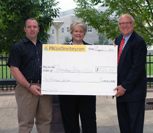 Debra M. Miller, director of corporate relations at Pennsylvania College of Technology, accepts a %241,000 scholarship check from Curt Parsons, district manager for Weatherford International Ltd., Fracturing Technologies Division, left%3B and Joe Barone, president of PAGasDirectory.com.