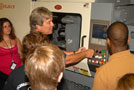 Timothy E. Weston, assistant professor of plastics technology, helps to demonstrate injection molding