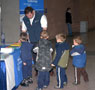 Admissions representative Brian D. Walton distributes Wildcat coloring books to a lineup of Little Lions