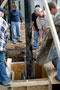 Supervised by Wayne E. Gebhart, assistant professor of electrical technology/occupations (in blue shirt), and Harry W. Hintz, instructor of construction technology, students pour concrete to set support poles