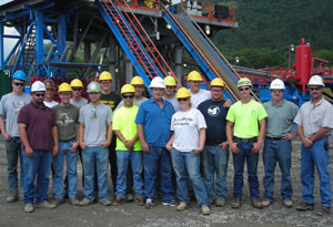 Budd L. Greevy, an instructor of diesel equipment technology at Pennsylvania College of Technology (right) and Jeffrey F. Lorson, an industrial technology specialist with the college%E2%80%99s Workforce Development and Continuing Education office (second from right), join Greevy%E2%80%99s heavy construction equipment students in a tour of Chief Oil %26 Gas%E2%80%99 drilling operation in western Lycoming County. Also accompanying the group are Ryan W. Peck, a lab assistant for diesel equipment technology at Penn College (maroon shirt at left), and Dave Roberts, Chief Oil %26 Gas drilling manager (in white hard hat at center).